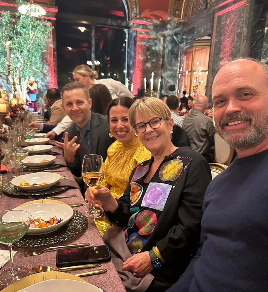 Team members enjoying dinner together at a candlelit table during a festive evening outing