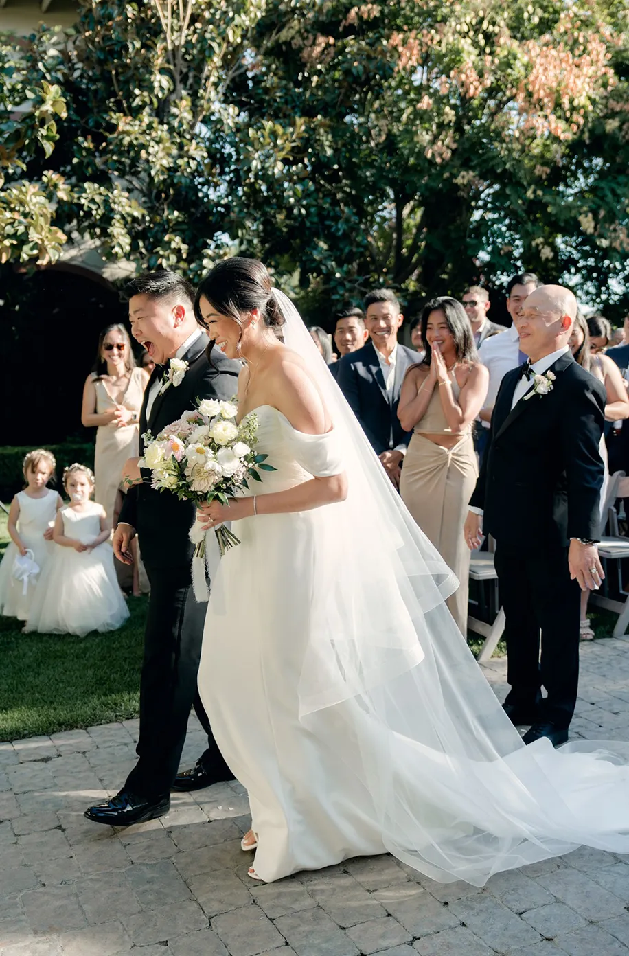 Bride and groom sharing a kiss as they walk down the aisle after their outdoor ceremony