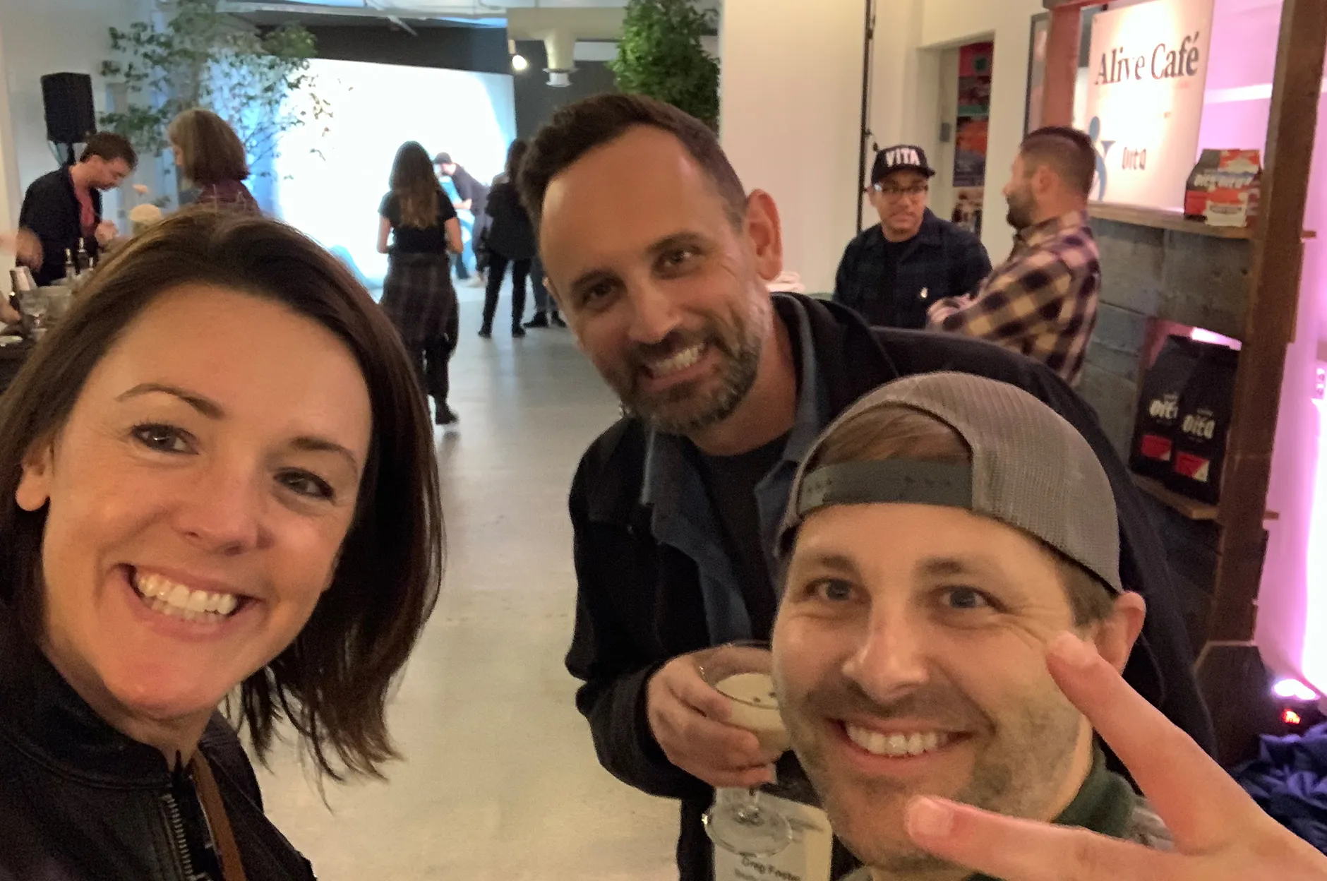 Three team members taking a selfie at a cafe during an industry event