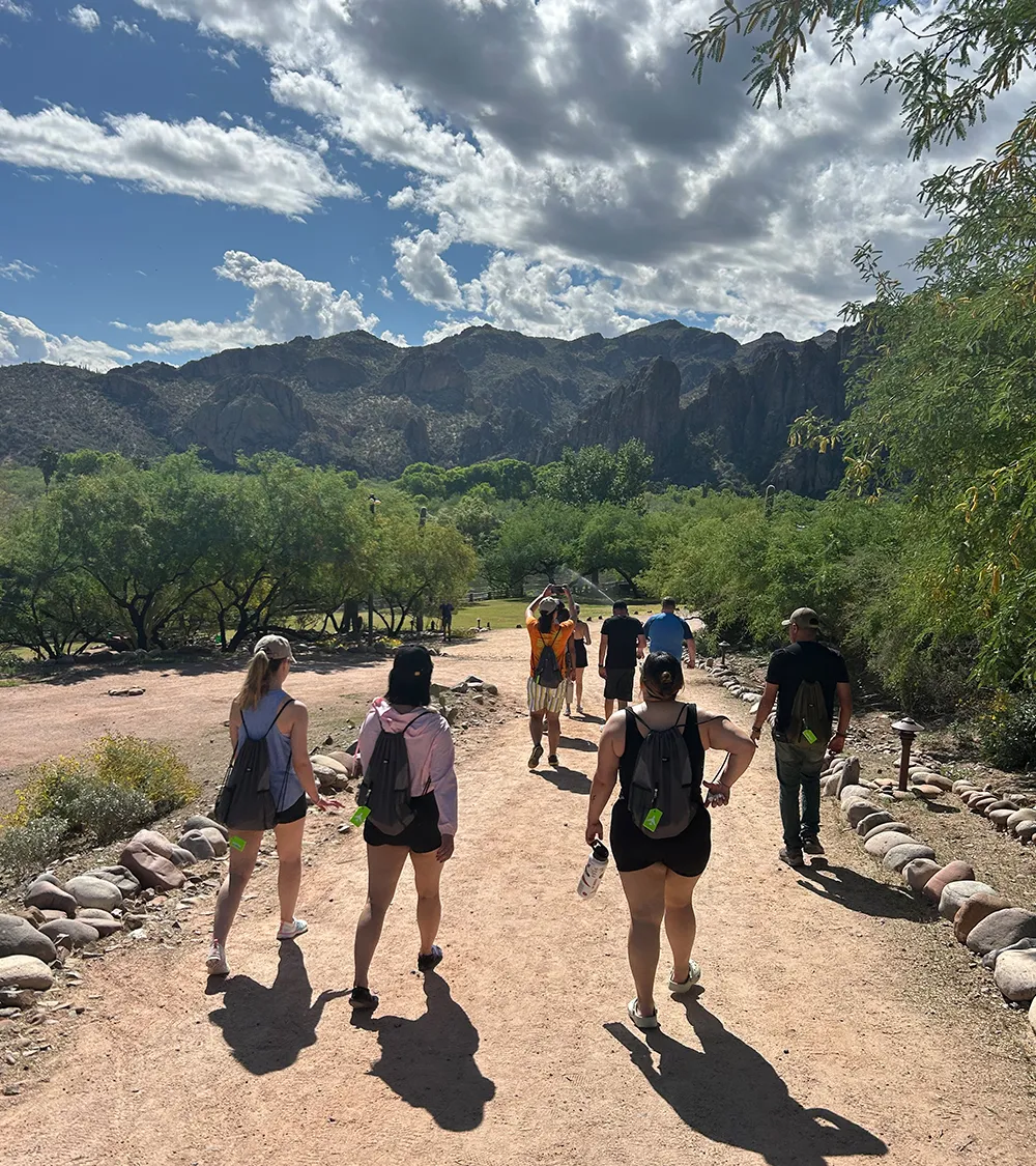 Team members hiking together on a trail surrounded by mountains
