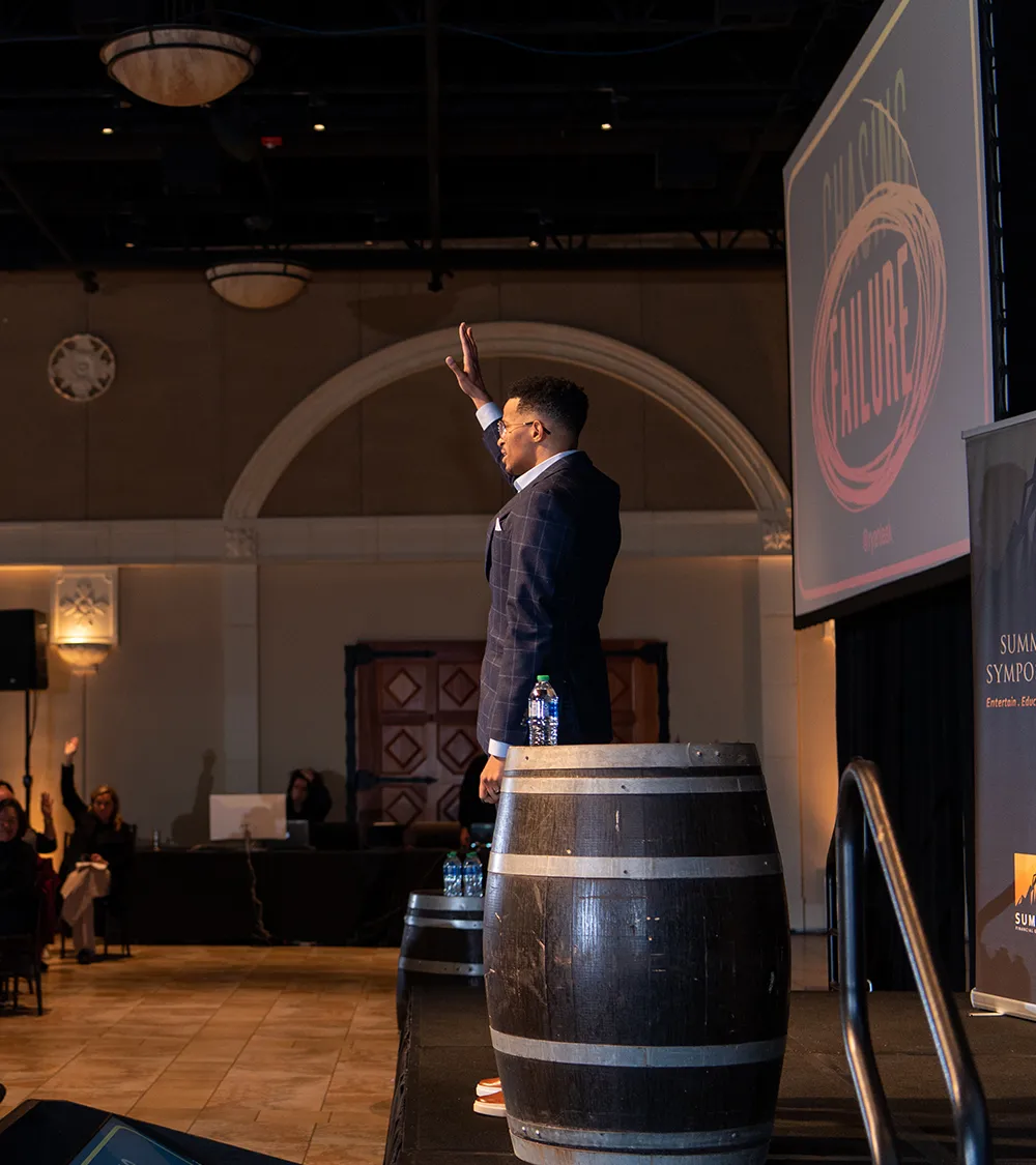 Keynote speaker addressing an audience from a stage at a corporate summit